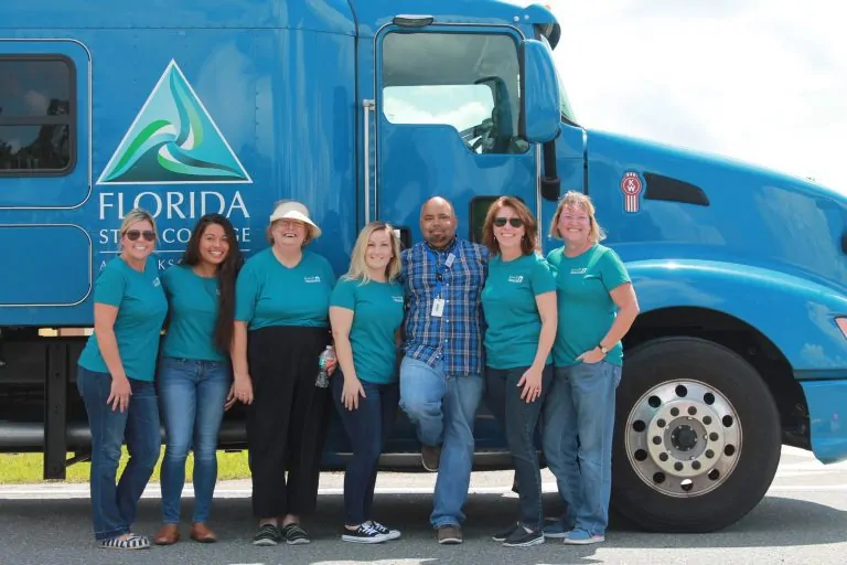 Staff standing against truck.