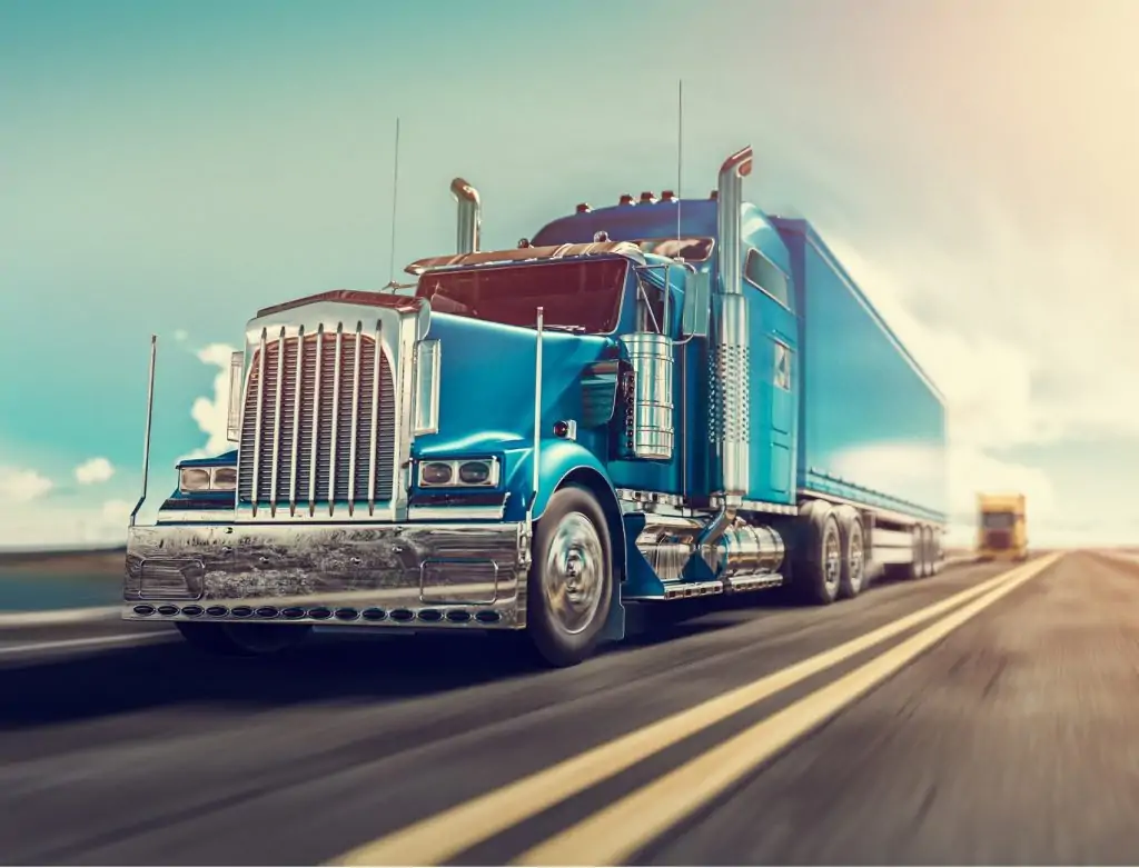 A blue semi-truck driving on highway.