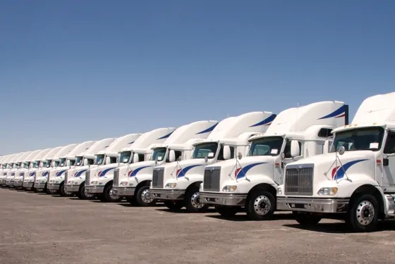 A long line of tractor trailer trucks.