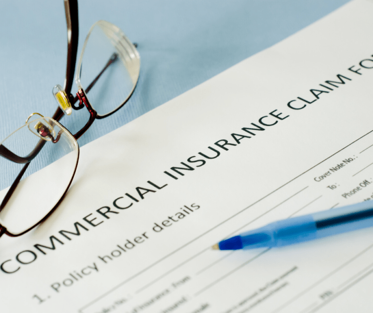 Commercial Insurance Claim Form with glasses & pen